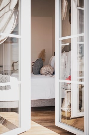 A bedroom with a bed, pillows, and a wardrobe.