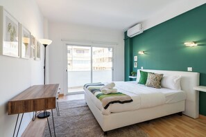 A modern bedroom with a bed, a desk, and a view of the outside. - Oracle 2-BR Apt. & Balcony in Larnaca (Larnaca)