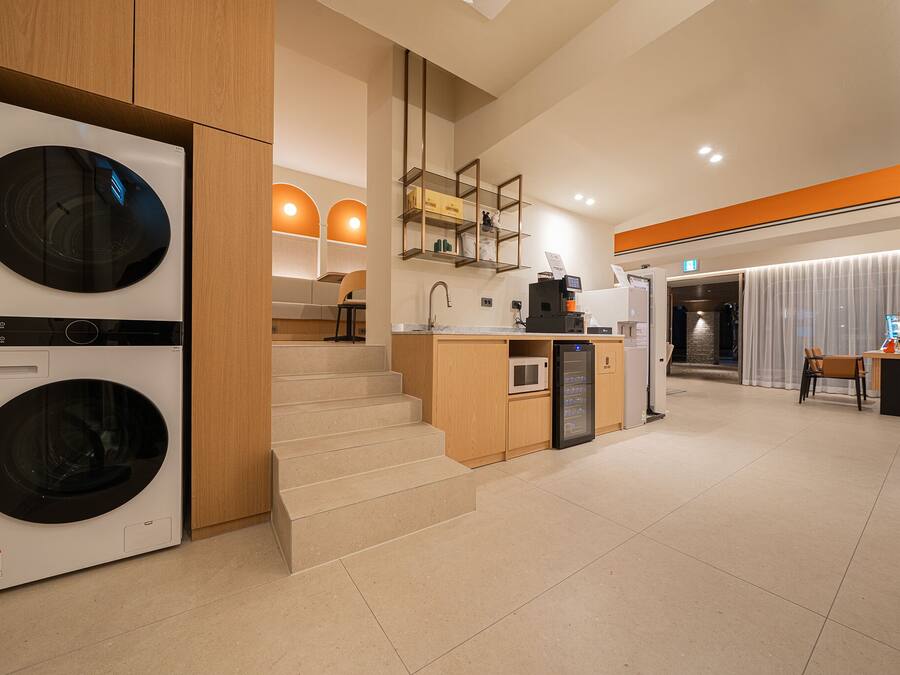 Une chambre d’hôtel moderne équipée d’un lave-linge, d’une kitchenette et d’un coin salon avec vue.