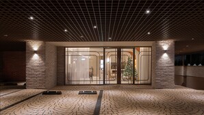 A modern building entrance with a brick facade, large glass doors, and a tiled floor. - Villa de Boni (Seoul)