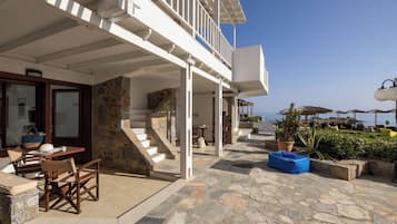 A coastal property with a stone staircase, outdoor seating, and a view of the sea.