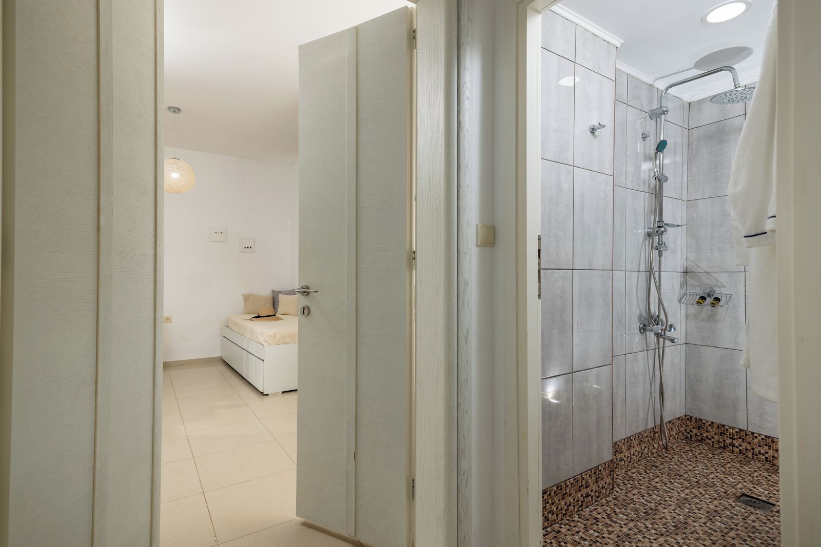 A modern bathroom with a shower, a toilet, and a sink.