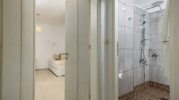 A modern bathroom with a shower, a toilet, and a sink.