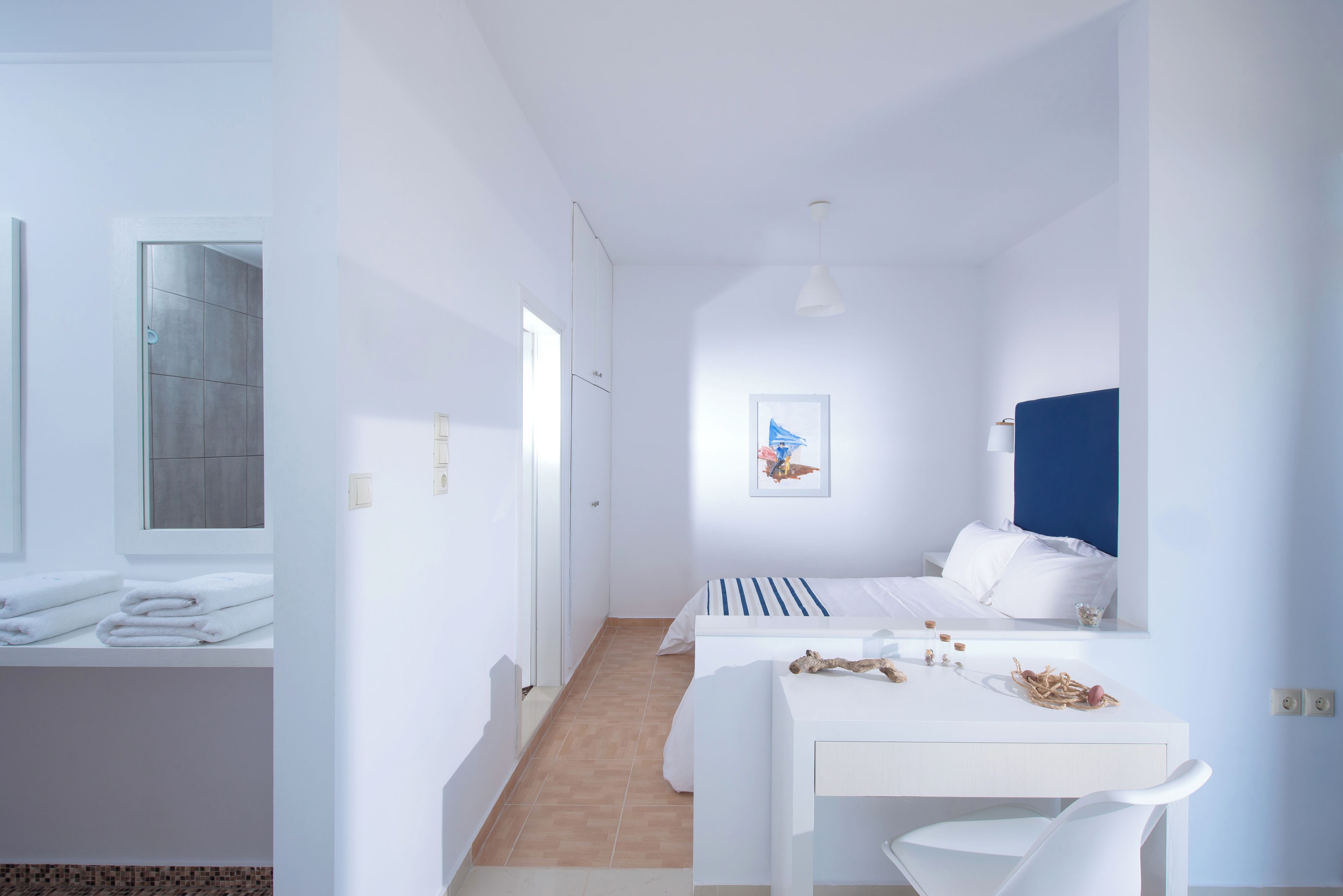 Un dormitorio moderno y minimalista con cama, mesita de noche y vistas al baño.