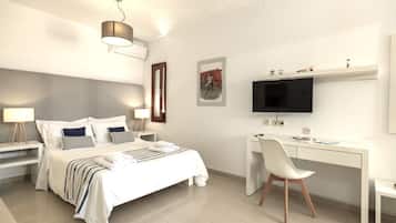A modern hotel room with a bed, bedside tables, a desk, a chair, a television, and artwork on the walls.