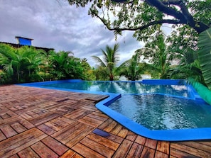 Een buitenzwembad, parasols voor strand/zwembad
