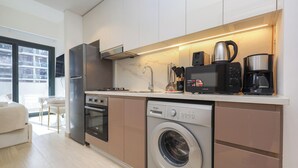 A modern kitchen with a built-in dishwasher, oven, and microwave. - Stylish Riviera Studio | Near Downtown (Dubai)