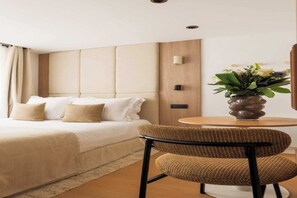 A hotel room with a bed, a round wooden table, a wicker chair, and a vase of flowers. - Elegant Studio 2P – Montorgueil/Grands Boulevards (Paris)