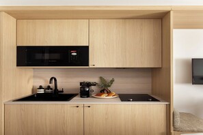 A compact kitchen with a Bosch microwave, a coffee maker, and a plate of food. - Cosy and modern studio- Jardin de Luxembourg (Paris)