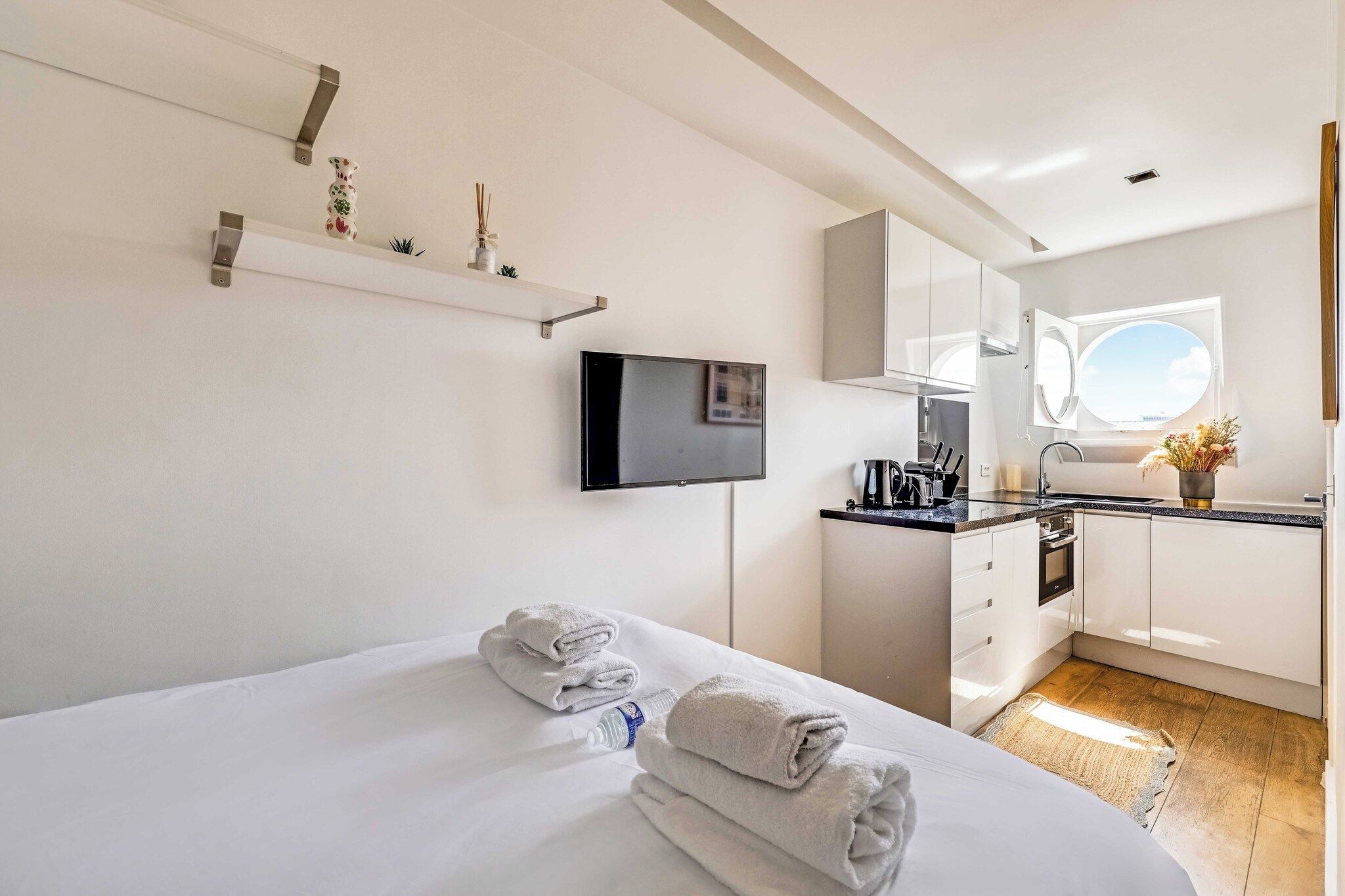 Une chambre d’hôtel équipée d’un lit, d’une télévision, d’un coin cuisine et d’une fenêtre.
