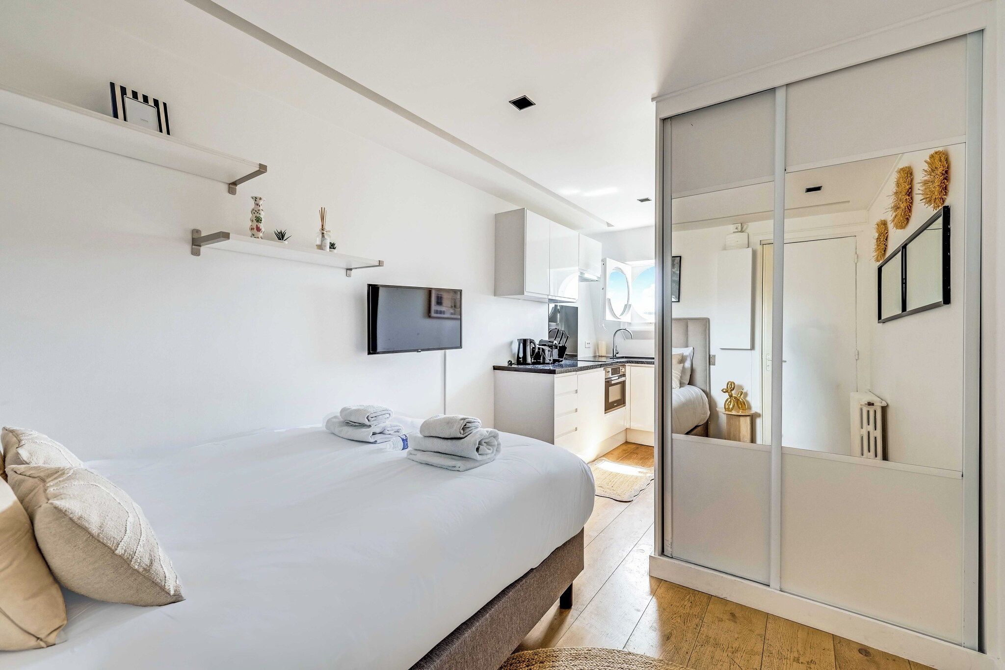 A modern bedroom with a bed, bedside table, and a TV.