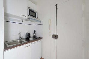 A kitchen with a microwave, coffee maker, and a sink. - Elegant Studio 2P – Paris 14 (Paris)