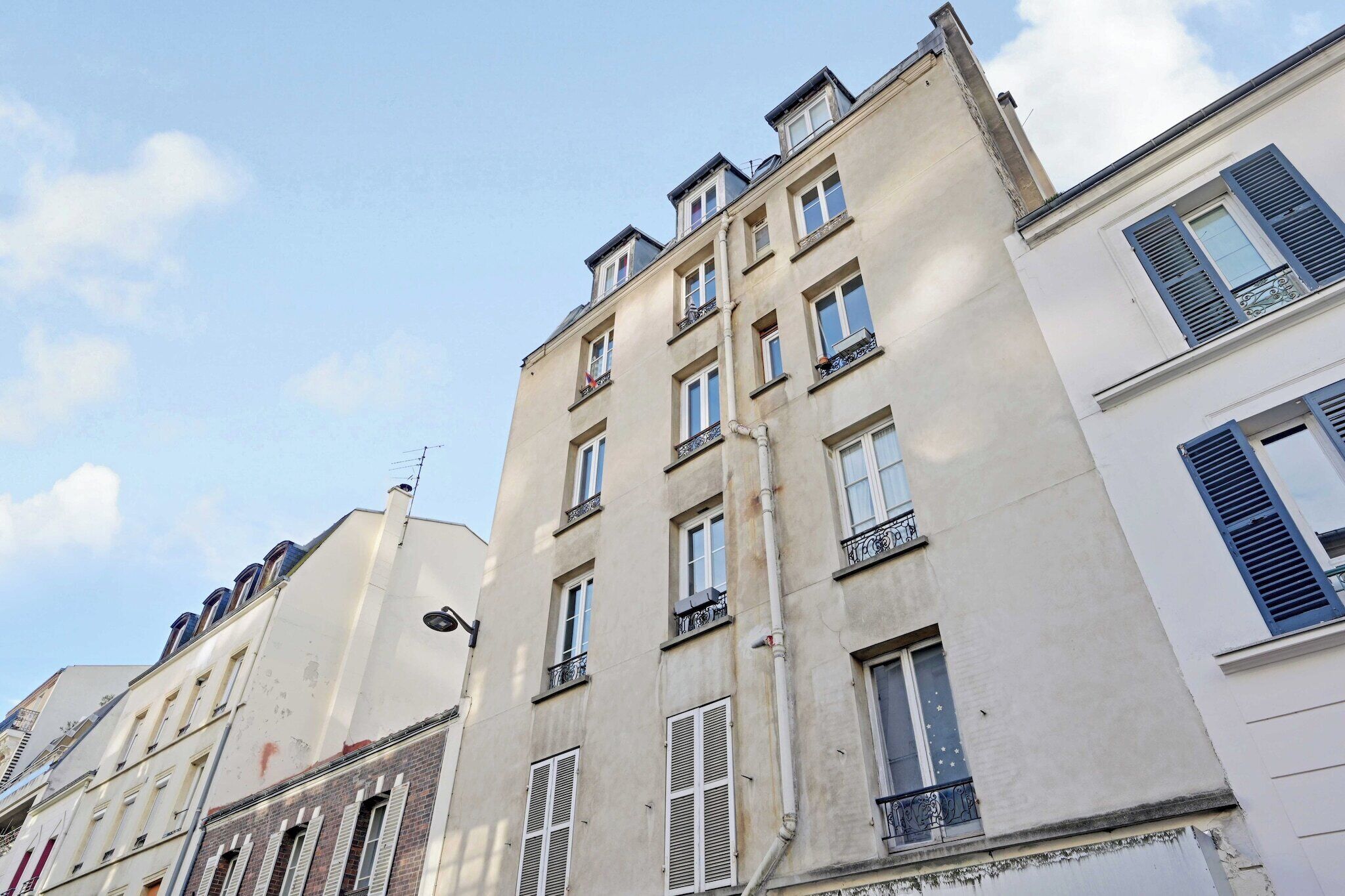 Ein mehrstöckiges Gebäude im klassischen Stil, mit Balkonen und einheitlicher Fassade.