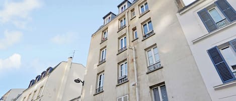 A multi-story building with a classic architectural style, featuring balconies and a uniform facade.