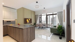 Eine moderne Küche mit Kochinsel, Essbereich mit Blick und Wohnbereich mit Sofa und Pflanzen.