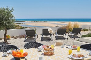 Taula preparada per esmorzar amb vista a la platja.