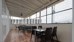 A spacious room with a high ceiling, large windows, and a wooden floor. - Hotel Amulya Relax Inn  (Bengaluru)