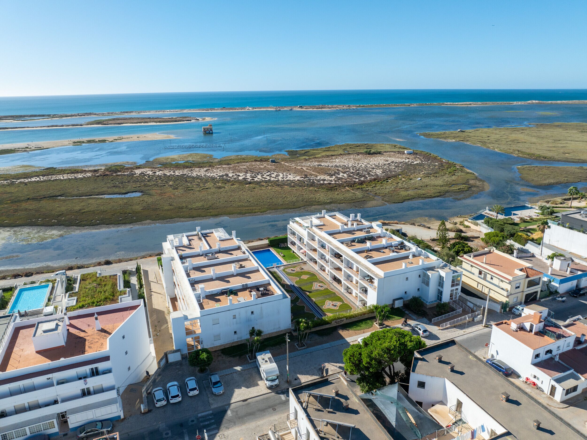 A coastal hotel with multiple floors, a swimming pool, and views of the sea and beaches.
