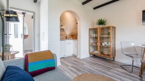 Una sala de estar moderna con un sofá, una mesa de vidrio transparente y un mueble de madera.