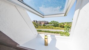 Ventana de tragaluz con vistas a una zona residencial, una carretera y zonas verdes.