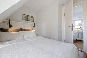A bedroom with a large bed, a ceiling lamp, and a framed picture on the wall. - Petit Dünenhof, Germany (Kampen (Sylt))