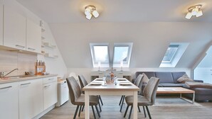 Een modern loft appartement met een eethoek, keuken en woonruimte.