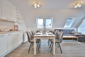 Un appartement moderne de style « loft » comprenant un coin repas, une cuisine et un espace de vie.