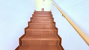 A staircase with a handrail leading to a door at the top. - Fewo Ostseelaune - directly by the forest and the sea - Ostseelaune - Comfortable apartment (Dranske)
