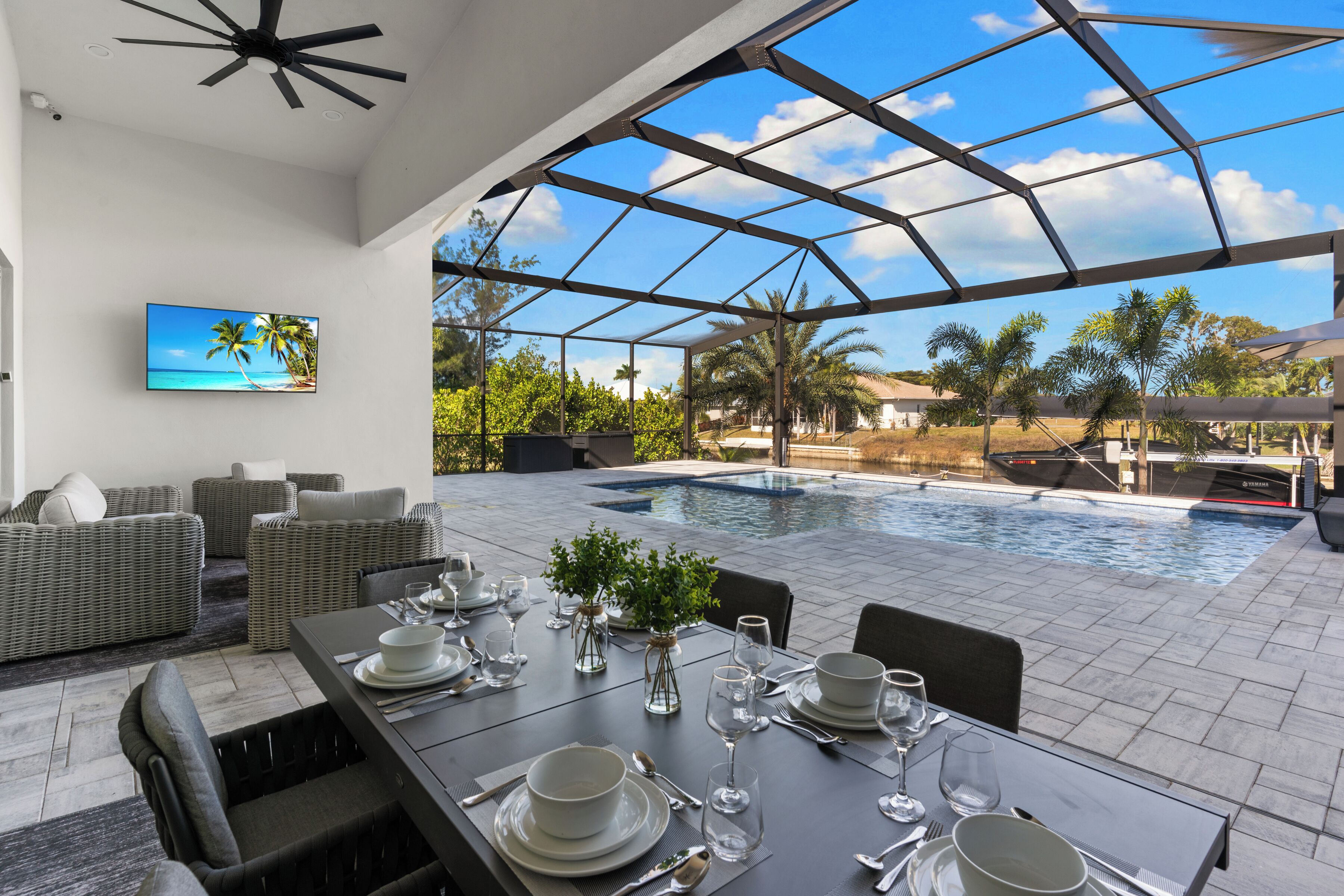 A modern outdoor dining area with a pool, comfortable seating, and a clear view of the pool and surrounding greenery.