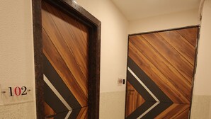 Un pasillo con dos puertas, cada una decorada con un diseño geométrico y el símbolo de número.