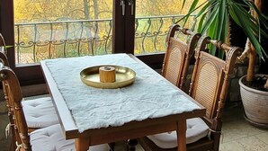 Ruokailutila, jossa on puinen pöytä, tuolit ja kattokruunu.