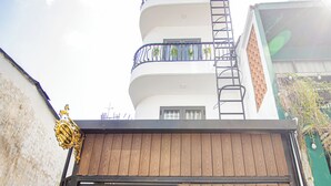 Een meerlaags gebouw met een houten poort en een metalen trap die naar een balkon leidt.