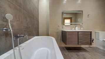 A modern bathroom with a freestanding bathtub, a vanity with a mirror, and a showerhead.