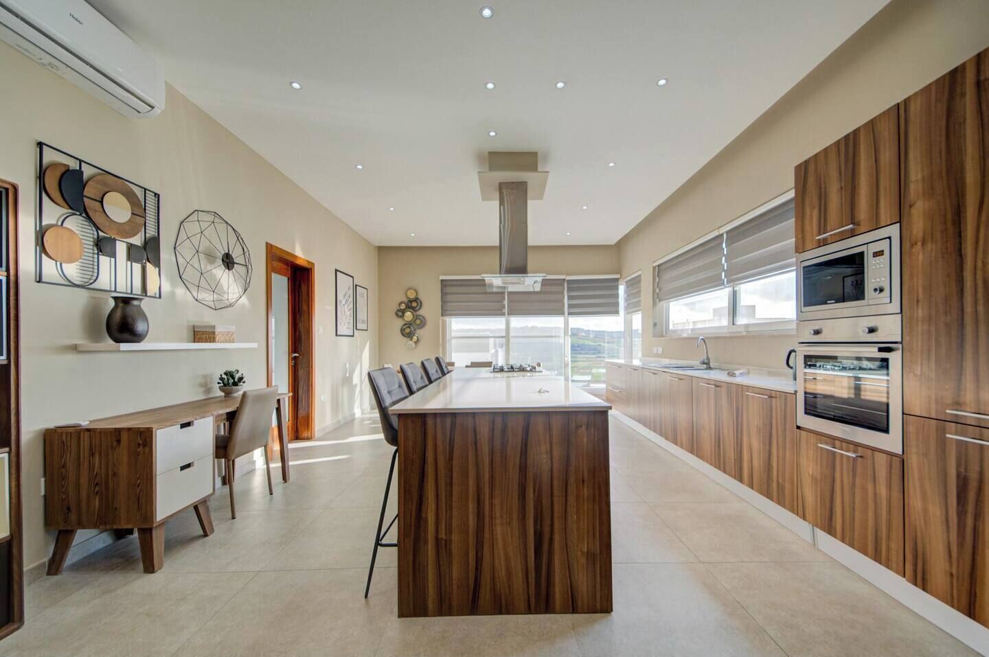 Una cocina moderna con una isla central, armarios de madera y electrodomésticos integrados.