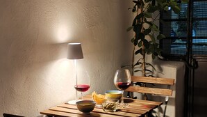 A dining area with a wooden table, two chairs, a lamp, and a potted plant. - SIKELIA HOUSE - COMFORT APARTMENT Hospitality and elegance in the heart of Palermo (Palermo)