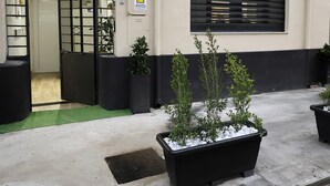 A building entrance with a metal gate, potted plants, and a sign indicating a video surveillance area. - SIKELIA HOUSE - COMFORT APARTMENT Hospitality and elegance in the heart of Palermo (Palermo)