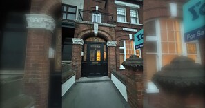 A brick building with a black door, a sign for Palliser Road, and a 'For Sale' sign. - Brilliantly Located 1BDR Flat in West Kensington (Greater London)