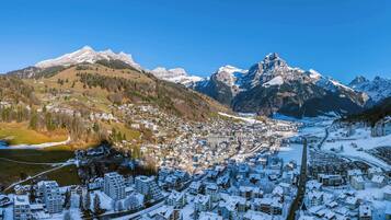 Un paese innevato con edifici e una montagna sullo sfondo.