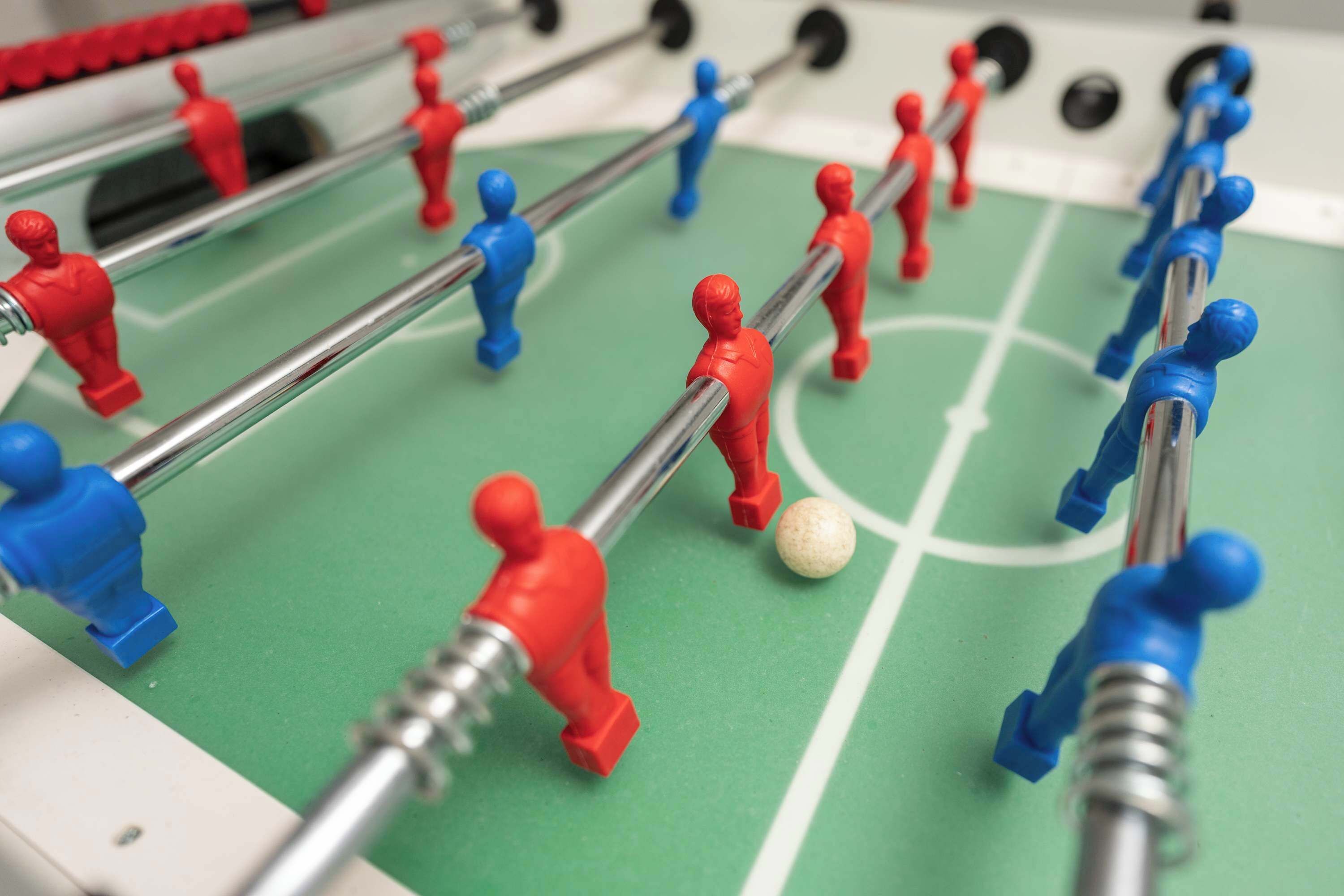 Un juego de fútbol de mesa con jugadores rojos y azules y una pelota.