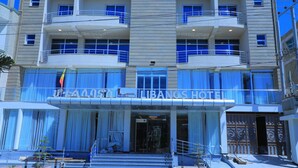 A multi-story hotel with balconies, a flag, and a sign reading "LIBANOS HOTEL". - Libanos Hotel (Mek'ele)