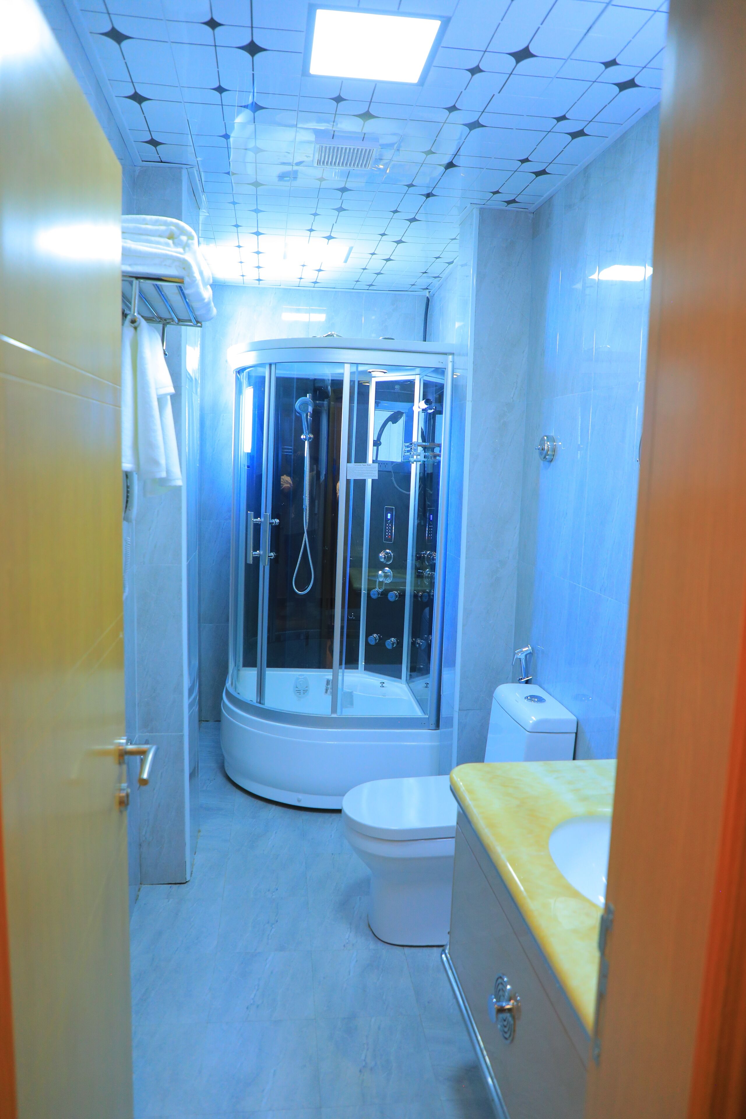 Une salle de bain avec une douche à parois de verre, des toilettes et un lavabo.
