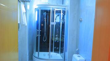 Une salle de bain avec une douche à parois de verre, des toilettes et un lavabo.