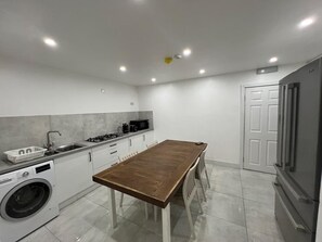 Una cocina moderna con una isla central, electrodomésticos integrados y un amplio ventanal.