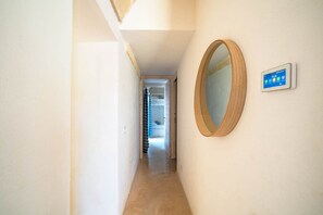 A narrow hallway with a wooden-framed mirror on the right wall and a digital clock displaying 13:20. - Trullo GiaMar · Private pool in olive grove, 3 bedrooms, dogs welcome · Ostuni (Ostuni)