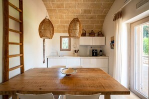 A wooden dining table with chairs, a hanging basket, and a ladder against the wall. - Trullo GiaMar · Private pool in olive grove, 3 bedrooms, dogs welcome · Ostuni (Ostuni)