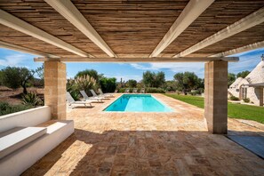 A covered outdoor swimming pool with stone flooring, lounge chairs, and a view of the surrounding landscape. - Trullo GiaMar · Private pool in olive grove, 3 bedrooms, dogs welcome · Ostuni (Ostuni)
