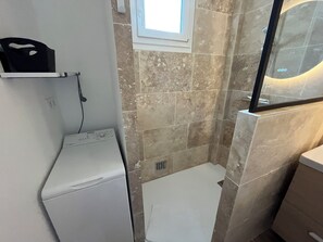 Regadera, secadora de cabello, toallas, papel de baño 