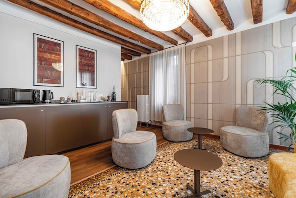 A modern interior with exposed wooden beams, a kitchen area, and seating arrangements. - Locanda Art Deco' (Venice)