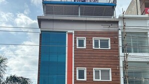 Un edificio de varios pisos con un letrero que dice "Hotel Saffron Restaurant & Bar" al nivel de la calle.
