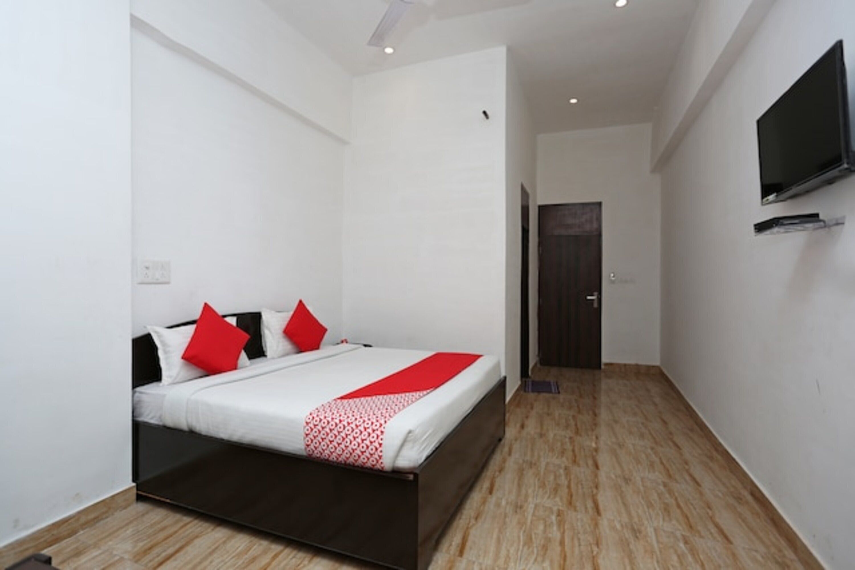 Una habitación de hotel moderna con una cama, un televisor y una puerta que da a otra habitación.